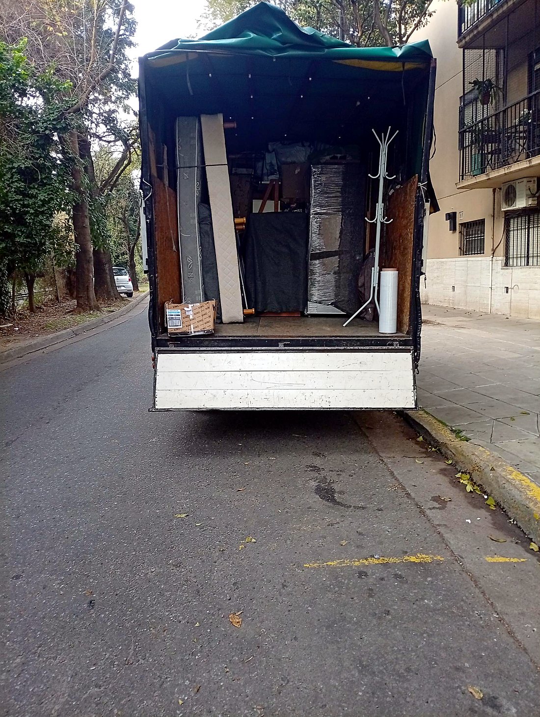 Colchones y perchero acomodados en el camión con lona verde